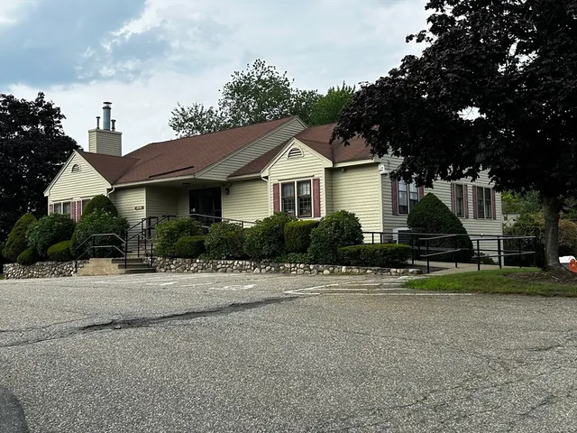 a front view of a house with a yard and trees