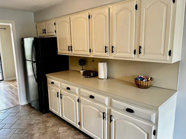 a kitchen with white cabinets and refrigerator