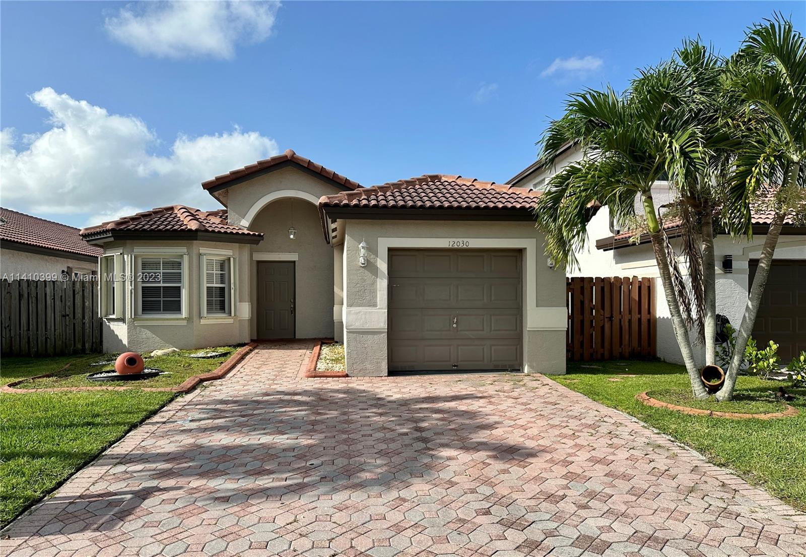 12030 Southwest 135th Terrace Miami, FL 33186 - Photo 1 of 27 a front view of a house with a yard and garage