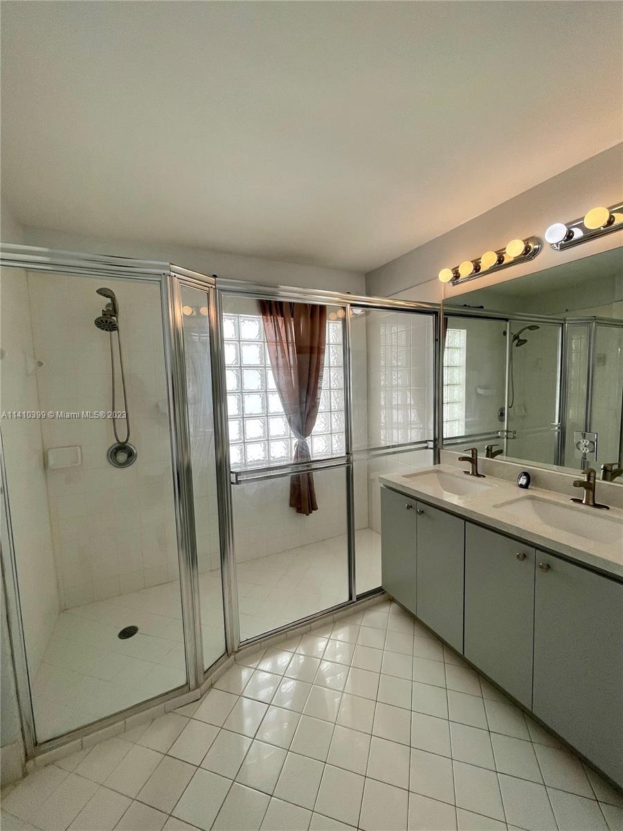 12030 Southwest 135th Terrace Miami, FL 33186 - Photo 13 of 27 a bathroom with a double vanity sink mirror and shower
