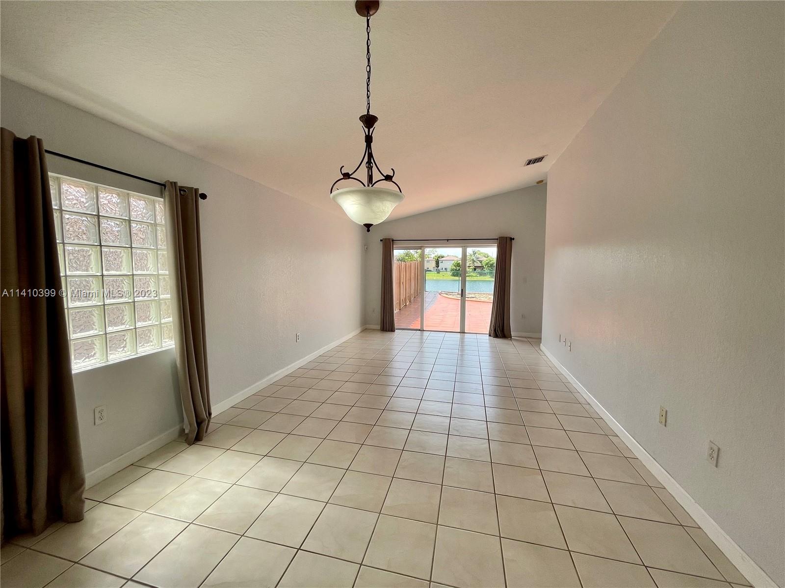 12030 Southwest 135th Terrace Miami, FL 33186 - Photo 2 of 27 a view of an empty room with window and chandelier fan