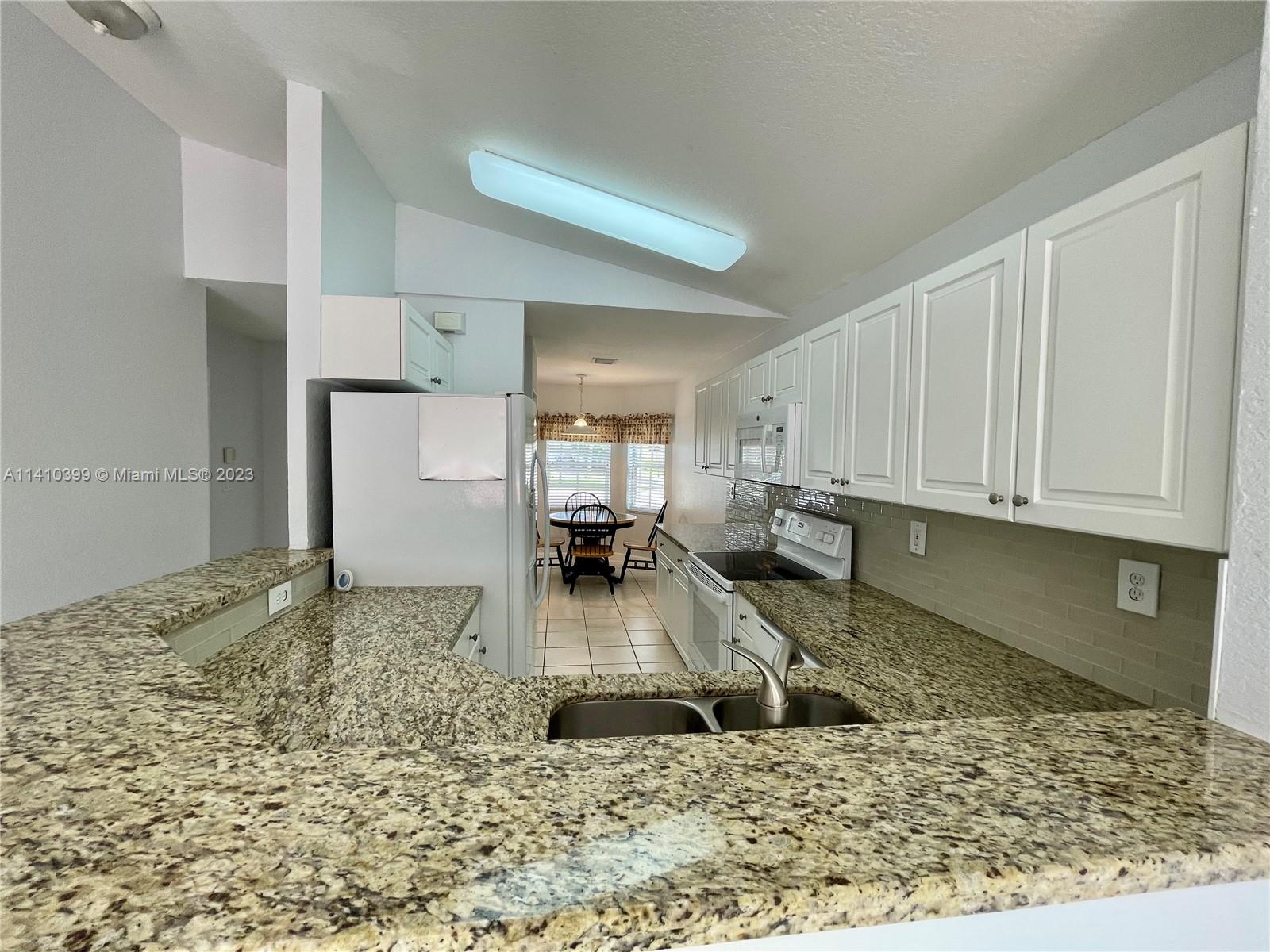 12030 Southwest 135th Terrace Miami, FL 33186 - Photo 3 of 27 a kitchen with a refrigerator and a sink