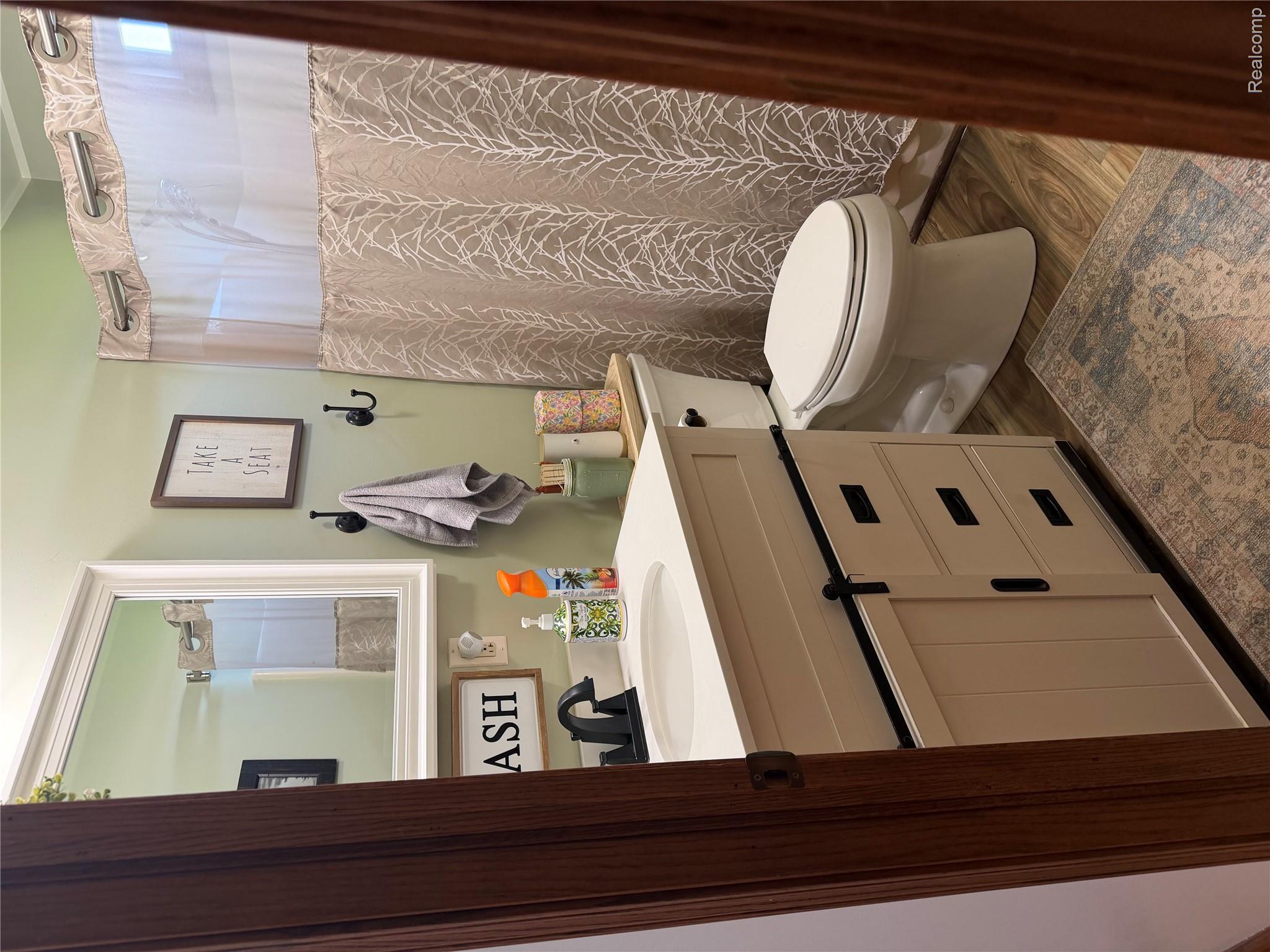 6860 Grand River Road Bancroft, MI 48414 - Photo 11 of 31 Bathroom featuring vanity, a shower with shower curtain, and dark wood-type flooring