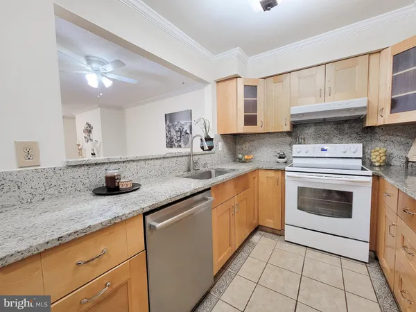 a kitchen with granite countertop a sink stainless steel appliances and cabinets