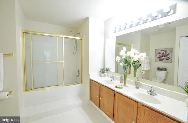 a bathroom with a granite countertop double vanity and a mirror