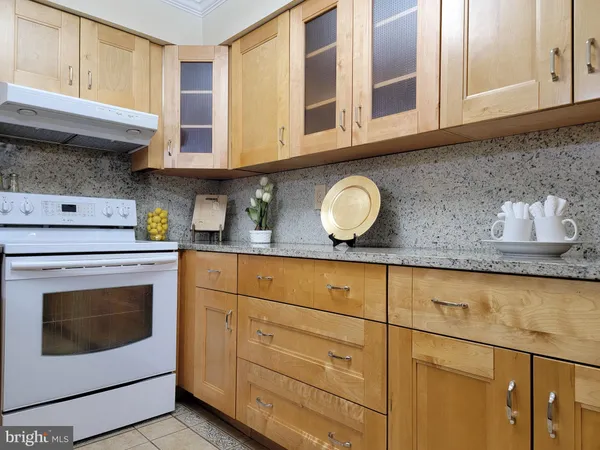 a kitchen with granite countertop cabinets stainless steel appliances and wooden floor