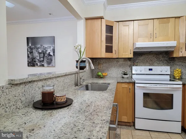 a kitchen with granite countertop a stove a sink and a microwave
