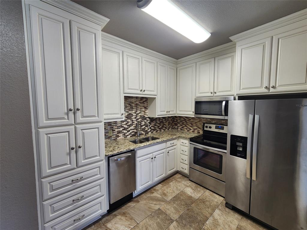 a kitchen with granite countertop stainless steel appliances and cabinets