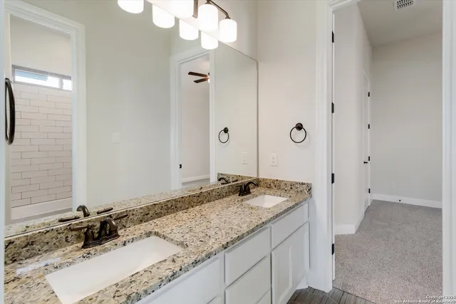 a bathroom with a granite countertop sink and a mirror