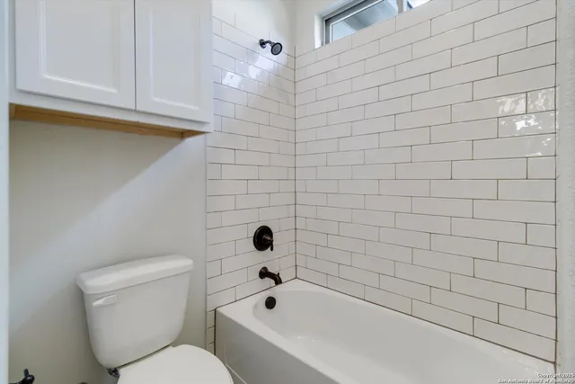 a bathroom with a toilet and bathtub