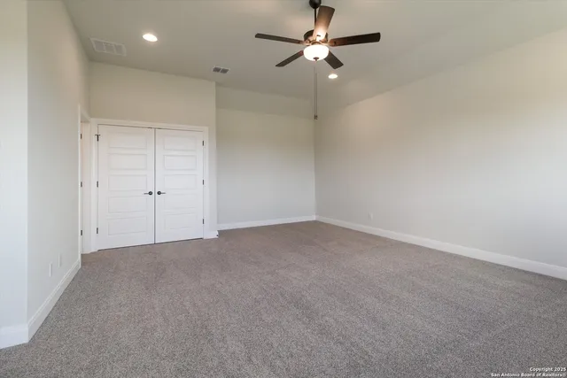 an empty room with a ceiling fan and a fan