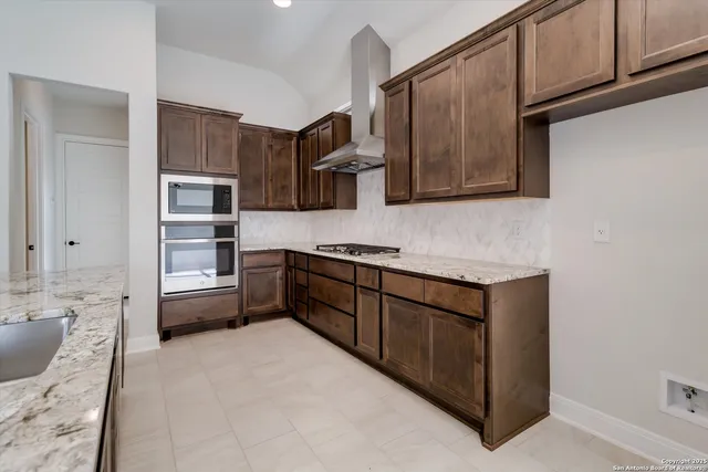 a kitchen with stainless steel appliances granite countertop a stove and a sink