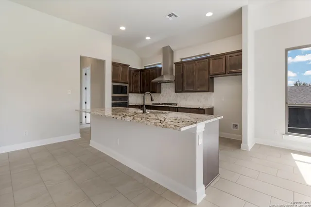a view of kitchen with stainless steel appliances granite countertop a refrigerator and a sink