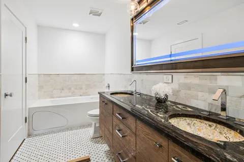 a bathroom with a granite countertop sink a toilet and a mirror