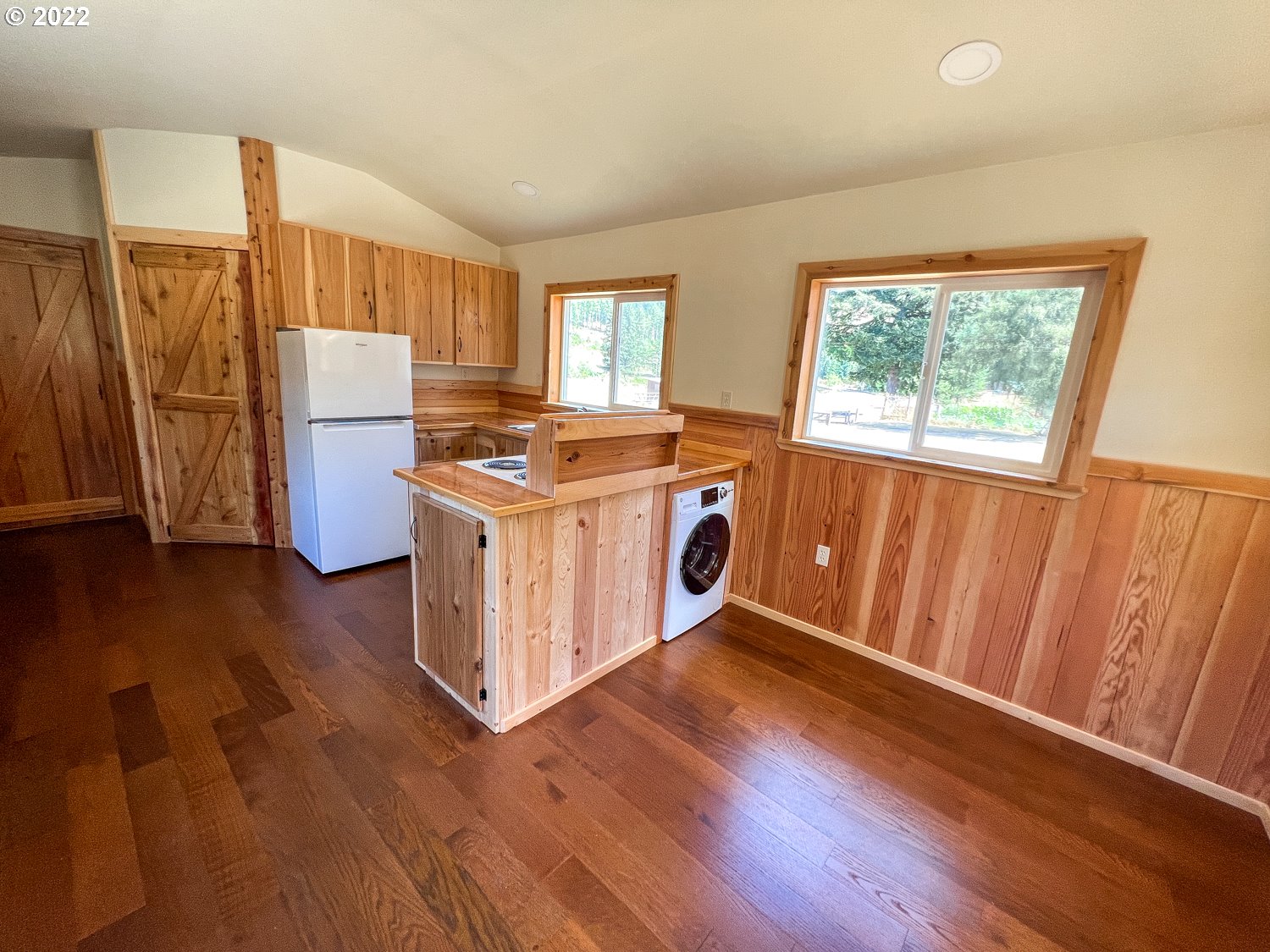 0 Bridge Tiny Home Myrtlepoint Or 97458 Myrtle Point, OR 97458 - Photo 16 of 18 a kitchen with a refrigerator a stove top oven a sink and wooden floor