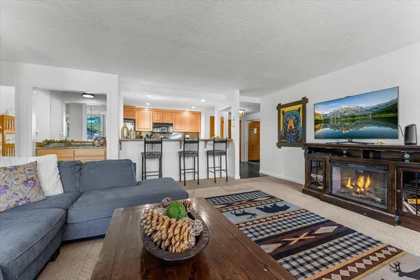 a living room with furniture fireplace and large windows