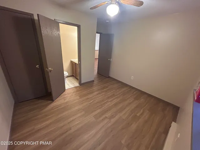 an empty room with wooden floor and mirror