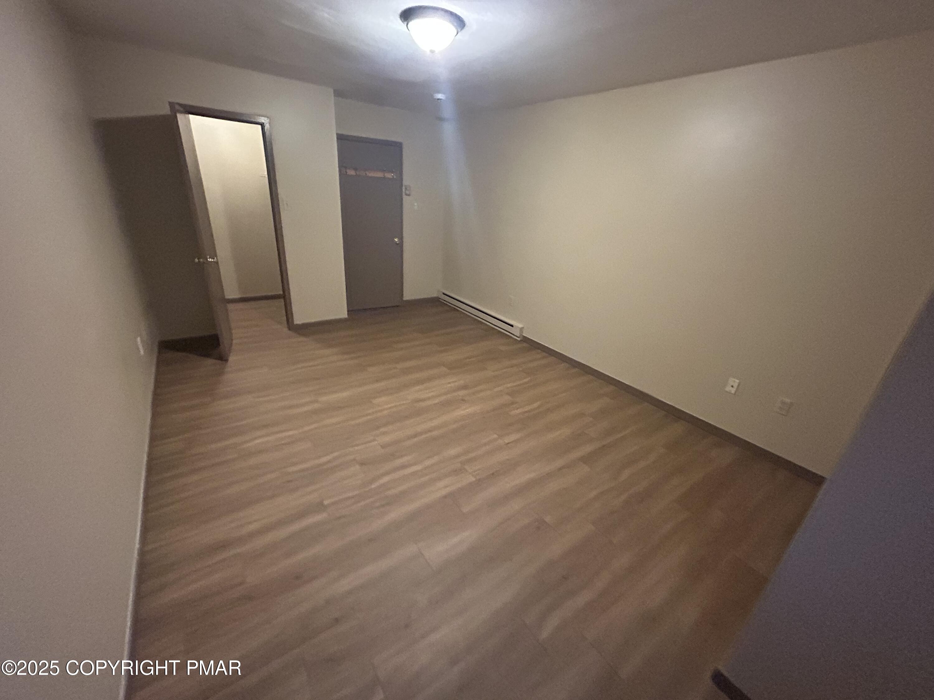 233 Sedburgh Court Bushkill, PA 18324 - Photo 6 of 14 an empty room with wooden floor and mirror