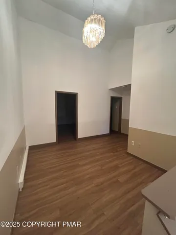 an empty room with wooden floor and workspace