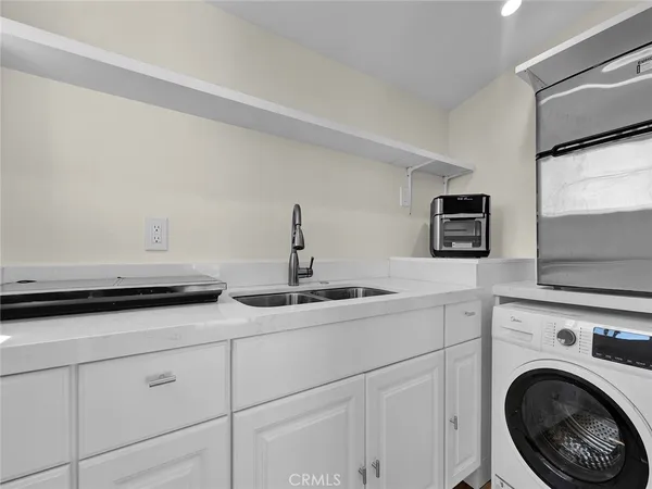 a kitchen with white cabinets and sink