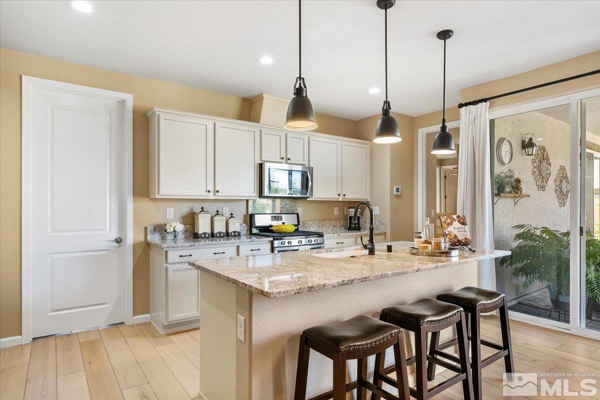 2315 Trakehner Lane Reno, NV 89521 - Photo 13 of 40 a kitchen with stainless steel appliances granite countertop a sink a stove a refrigerator and cabinets