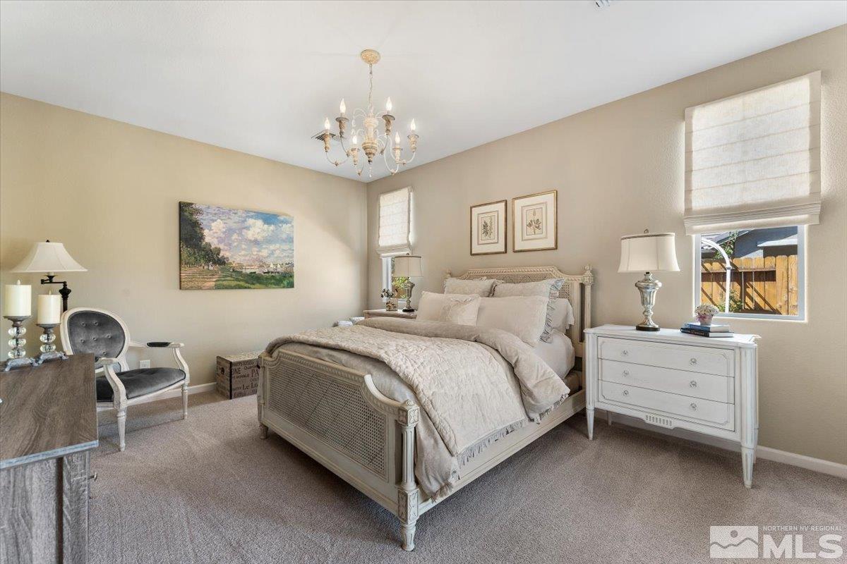 2315 Trakehner Lane Reno, NV 89521 - Photo 15 of 40 a spacious bedroom with a bed and a chandelier