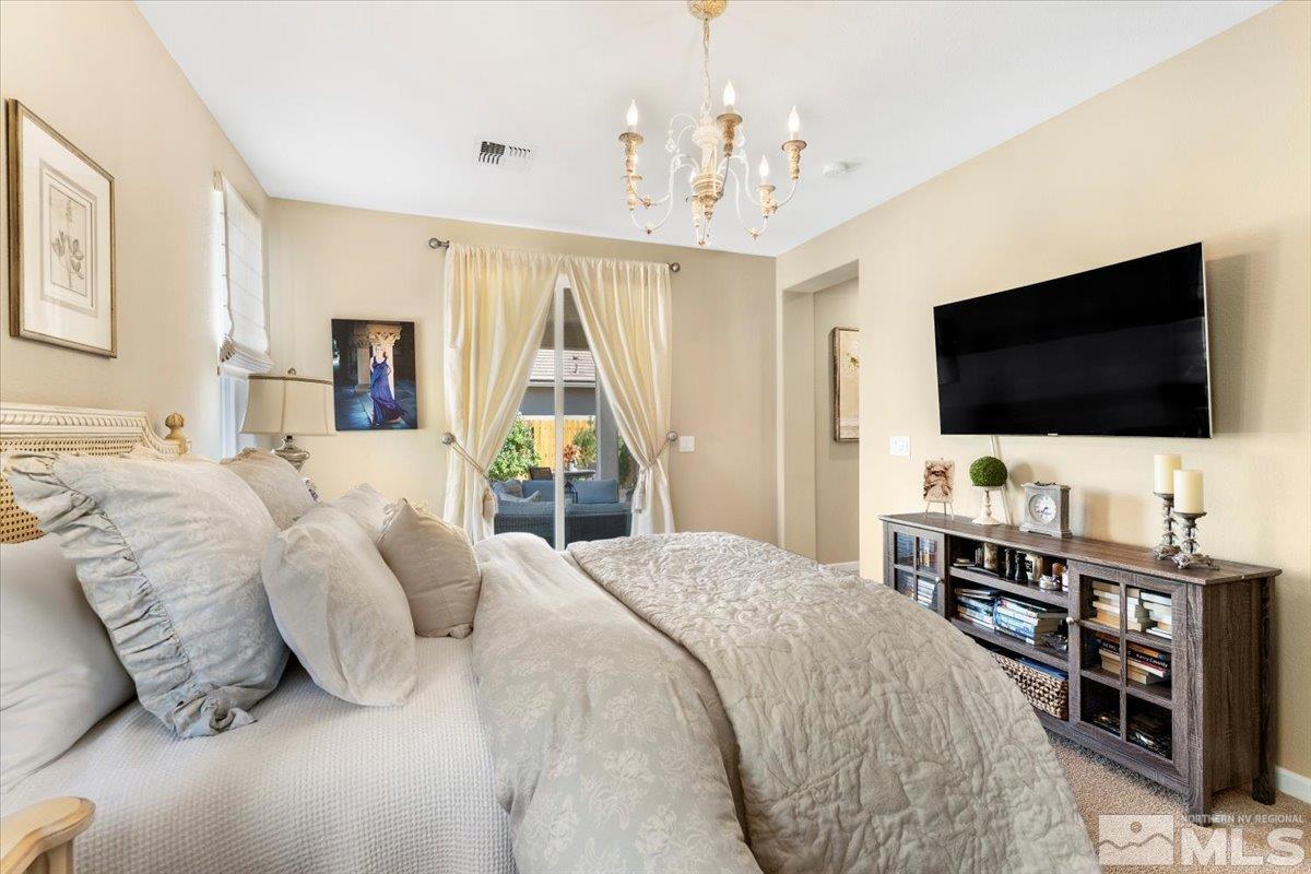 2315 Trakehner Lane Reno, NV 89521 - Photo 16 of 40 a bedroom with a bed and a flat tv screen on the dresser