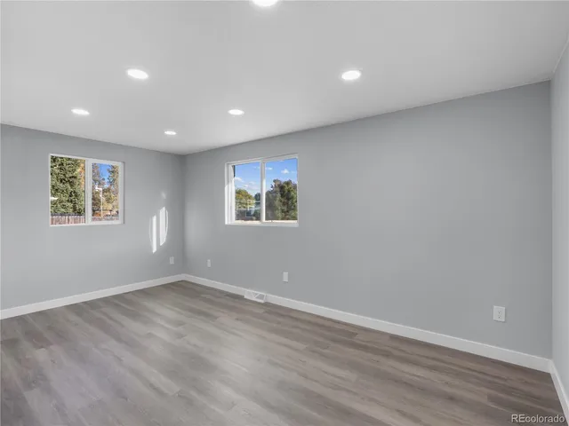 a view of empty room with wooden floor