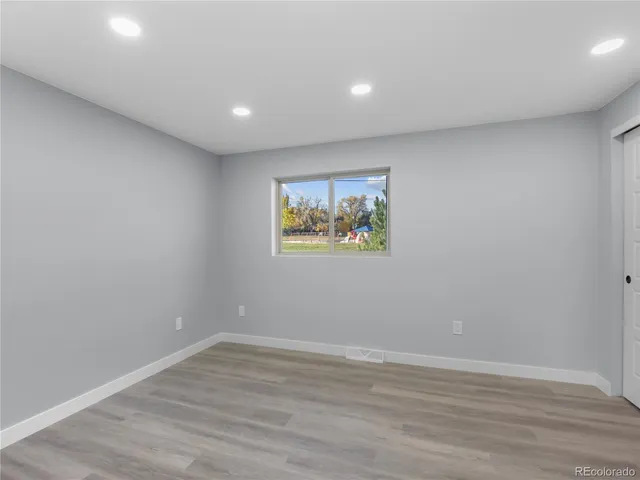 a view of empty room with wooden floor