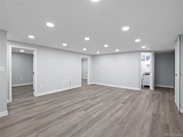 a view of an empty room with wooden floor and closet