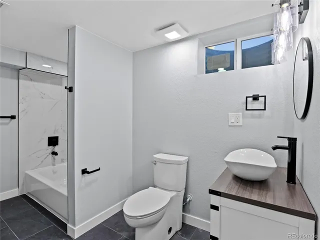 a bathroom with a toilet a sink and shower