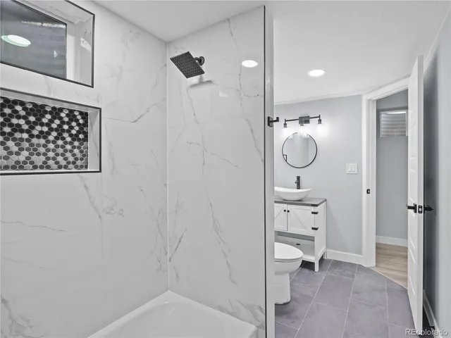 a bathroom with a granite countertop sink a toilet and a mirror