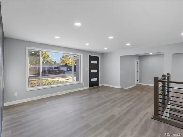 an empty room with wooden floor and window