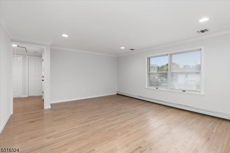 4 Coppola Street Nutley, NJ 07110 - Photo 5 of 14 an empty room with wooden floor and windows