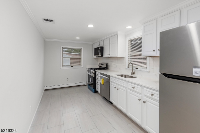 4 Coppola Street Nutley, NJ 07110 - Photo 7 of 14 a kitchen with stainless steel appliances a refrigerator sink and white cabinets