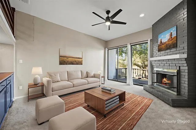 a living room with furniture a large window and a fireplace