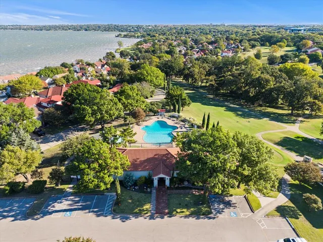 an aerial view of residential houses with outdoor space and lakeside