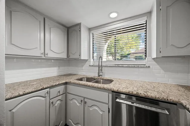 a kitchen with granite countertop a sink and a window
