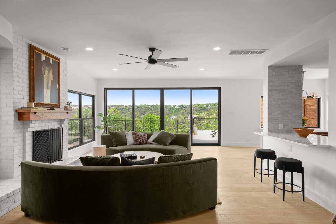 a living room with fireplace furniture and a large window