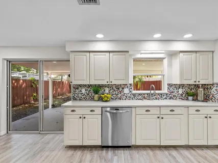 a kitchen with white cabinets and sink