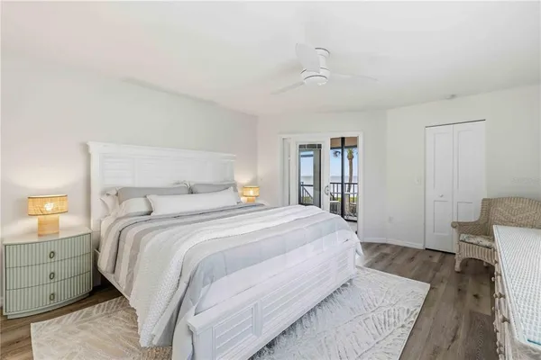 a bedroom with a large bed and wooden floor