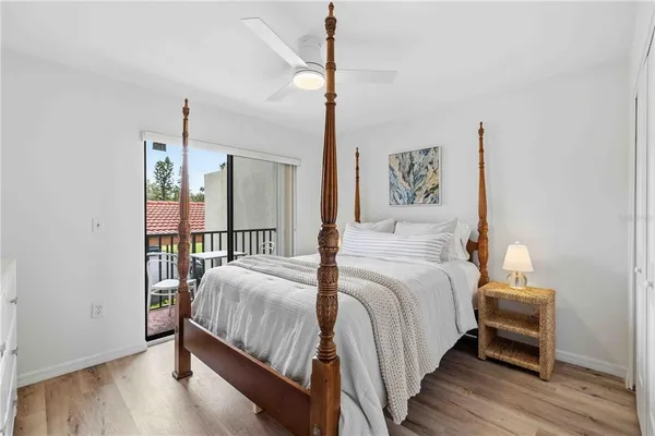 a bedroom with a bed a mirror and a wooden floor