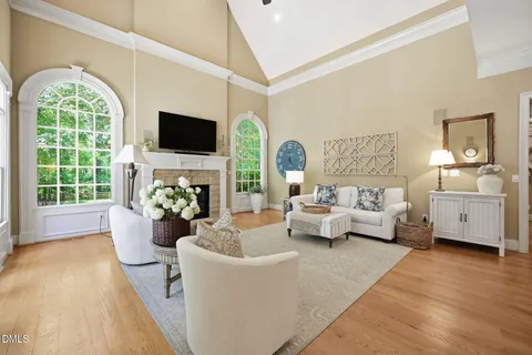 a living room with furniture a flat screen tv and a large window