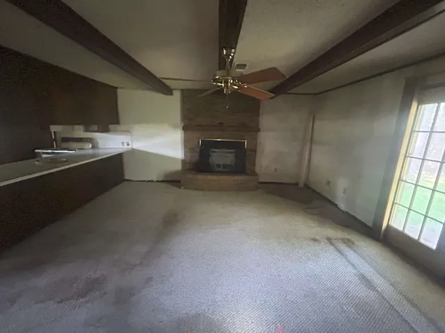 en empty room with windows and fireplace