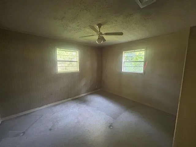 an empty room with windows and closet