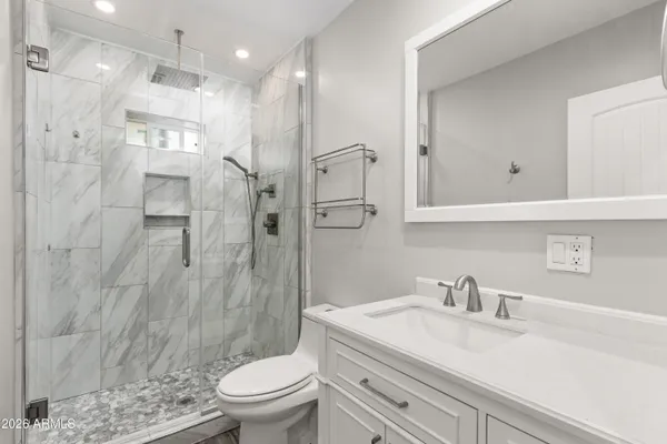 a bathroom with a sink a toilet and shower