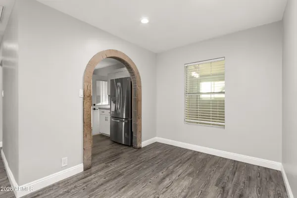 an empty room with a window and wooden floor