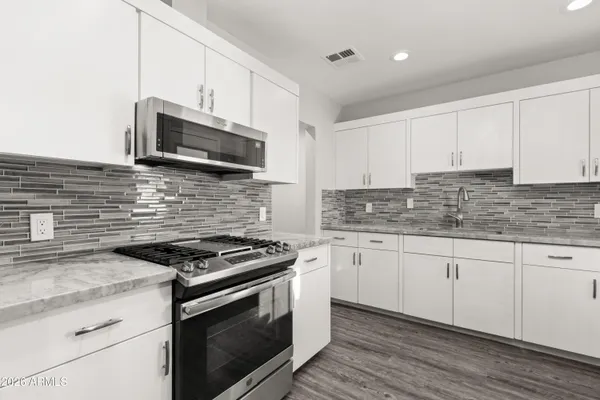 a kitchen with granite countertop cabinets stainless steel appliances and a sink