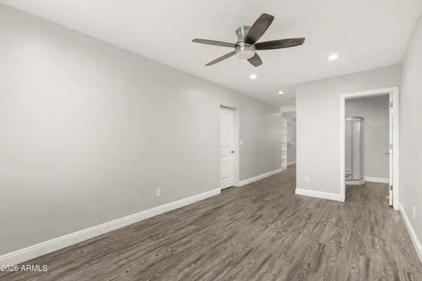 a view of a big room with wooden floor closet and windows