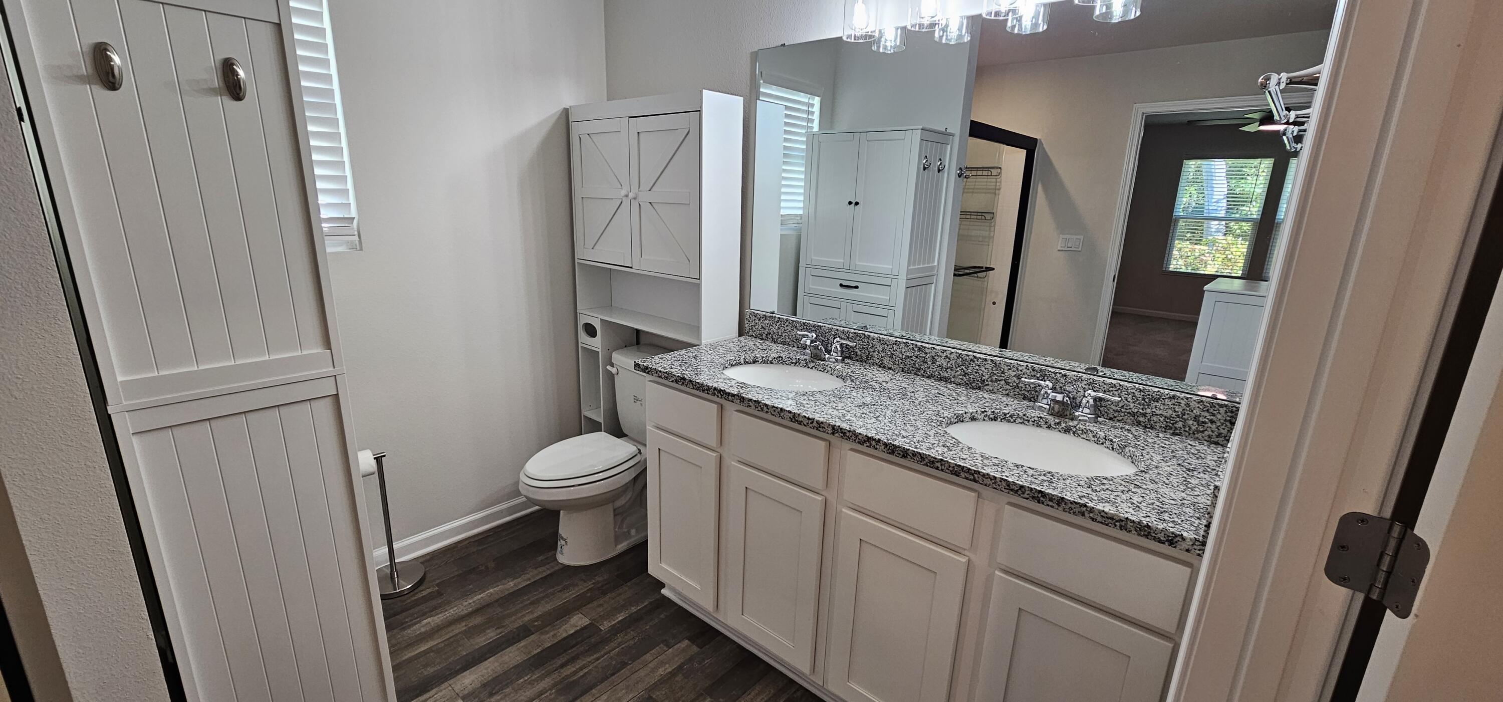 460 Riverwalk Circle Freeport, FL 32439 - Photo 11 of 25 a bathroom with a granite countertop toilet sink and a mirror